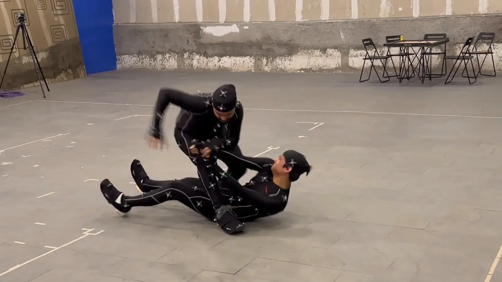 Two performers in motion capture suits rehearsing a fight